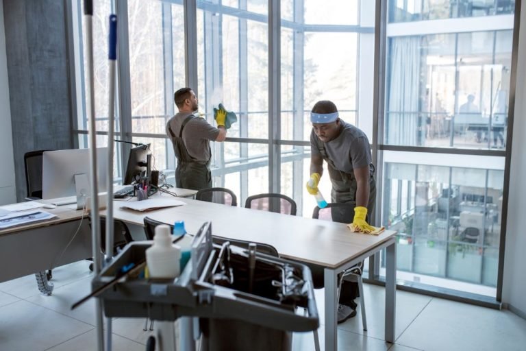Janitors cleaning office with cleaning materials